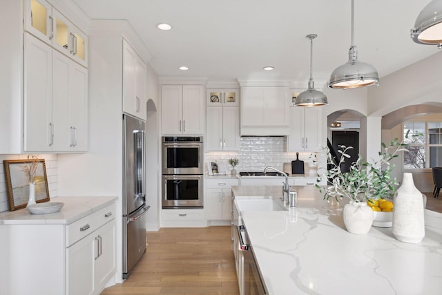 kitchen featuring white cabinetry, hanging light fixtures, and stainless steel appliances