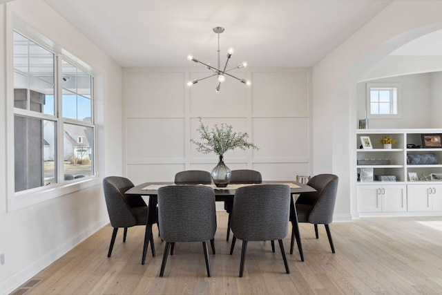 dining area featuring an inviting chandelier and light hardwood / wood-style floors