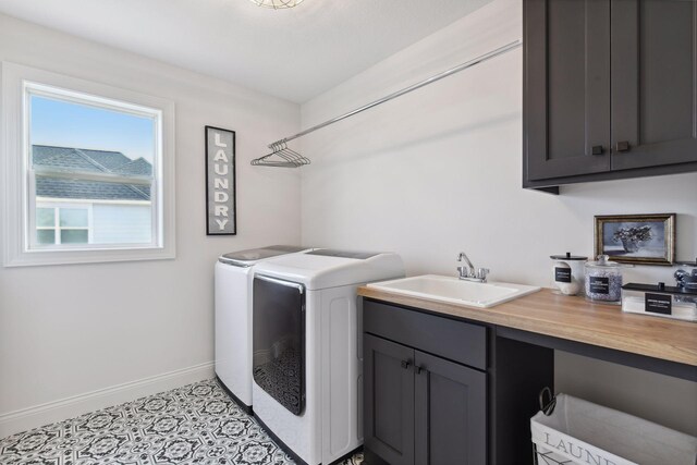 washroom with cabinets, washer and clothes dryer, sink, and light tile patterned floors