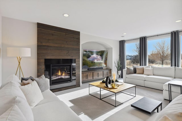 carpeted living room featuring a large fireplace