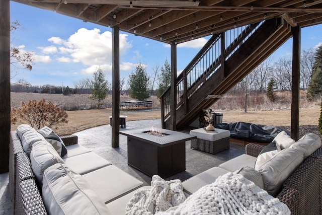 view of patio / terrace featuring a rural view and an outdoor living space with a fire pit