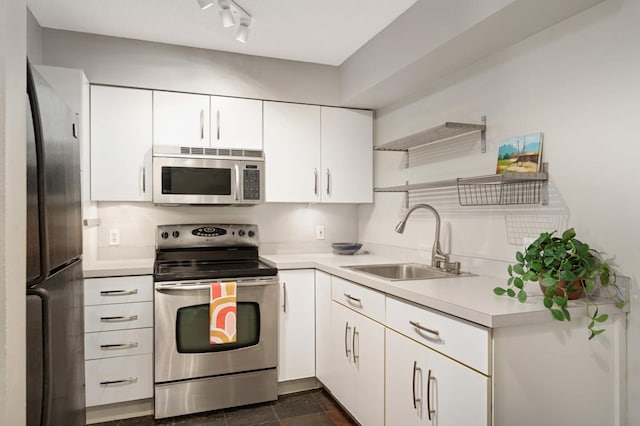 kitchen featuring track lighting, stainless steel appliances, sink, and white cabinets