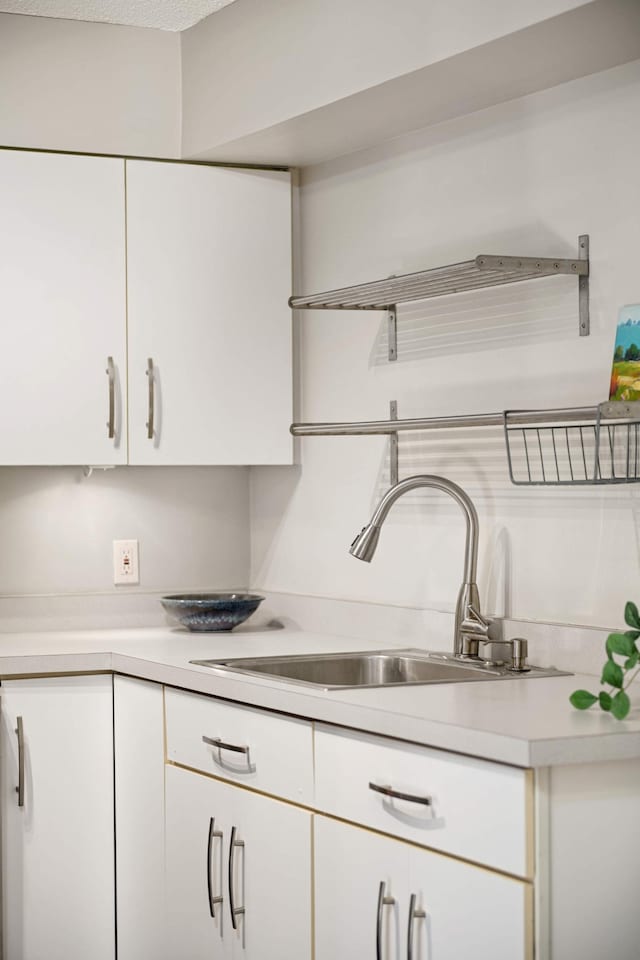 kitchen featuring sink, a textured ceiling, and white cabinets