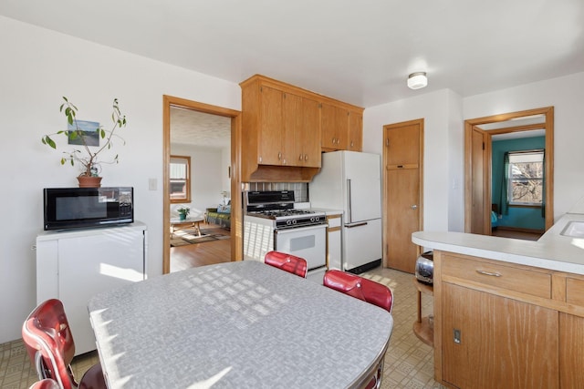 kitchen featuring tasteful backsplash and white appliances