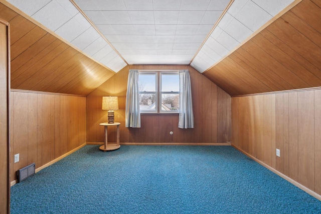 additional living space featuring carpet flooring and wood walls