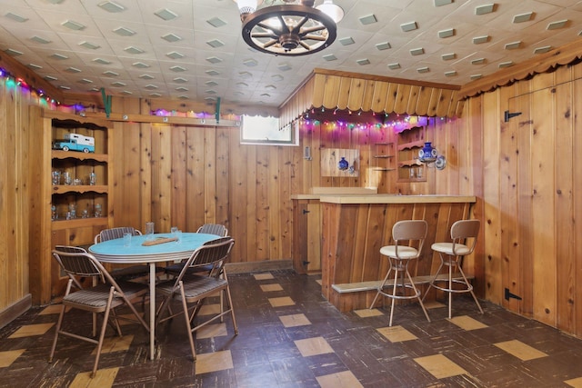 dining room with bar and wood walls