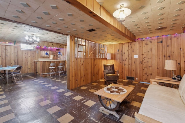 living room featuring bar and wood walls