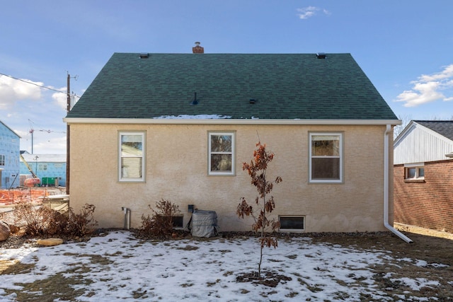 view of snow covered rear of property