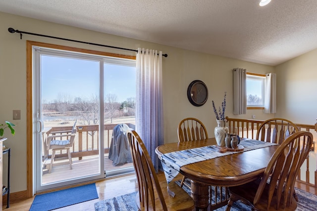 dining room with light hardwood / wood-style flooring and a textured ceiling