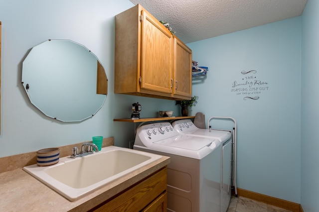 laundry room featuring separate washer and dryer, sink, cabinets, and a textured ceiling