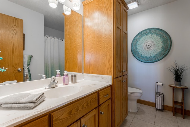 bathroom with vanity, tile patterned floors, a textured ceiling, and toilet