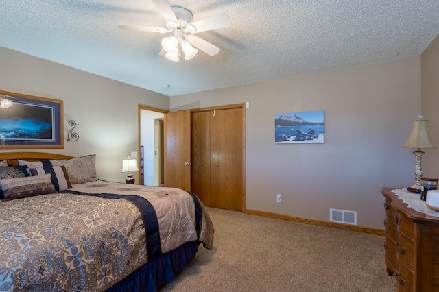 carpeted bedroom featuring ceiling fan, a textured ceiling, and a closet