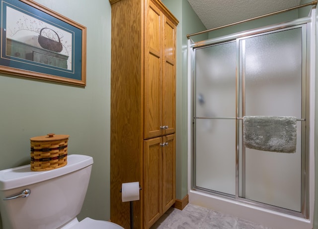 bathroom featuring an enclosed shower, a textured ceiling, and toilet