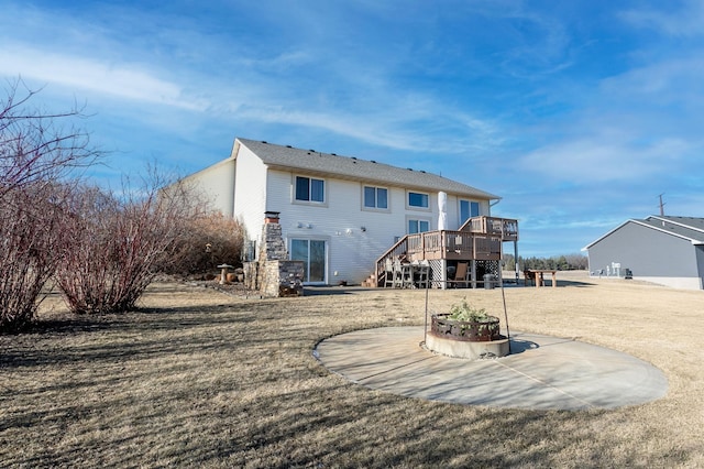 back of house featuring a wooden deck, a yard, and a patio area