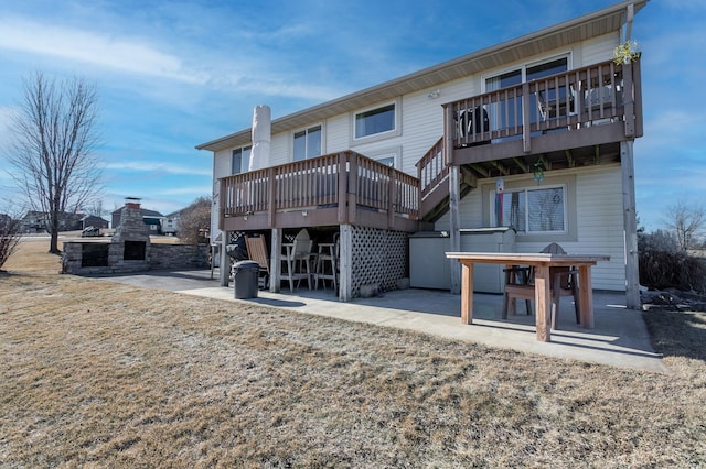 back of property with a wooden deck, a fireplace, and a patio area