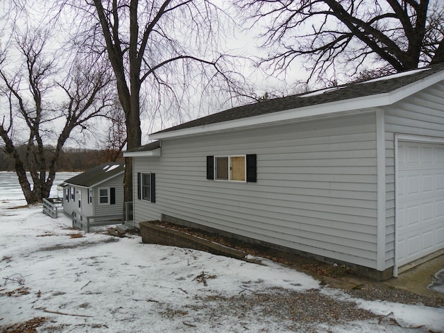 view of snowy exterior with a garage