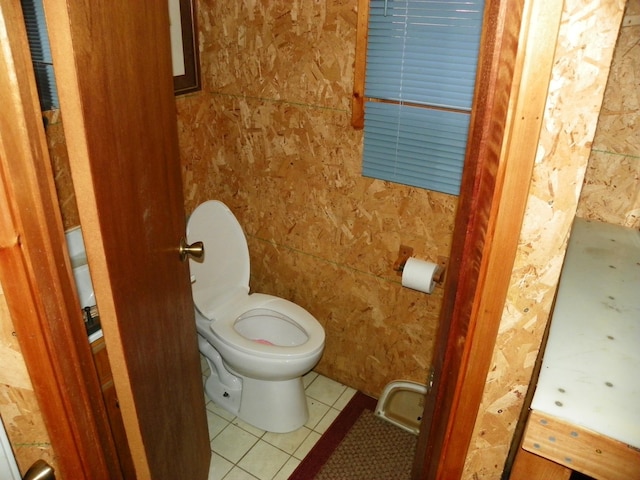 bathroom with tile patterned floors, toilet, and tile walls