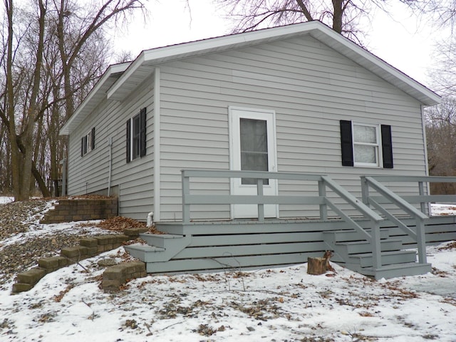 view of snow covered back of property