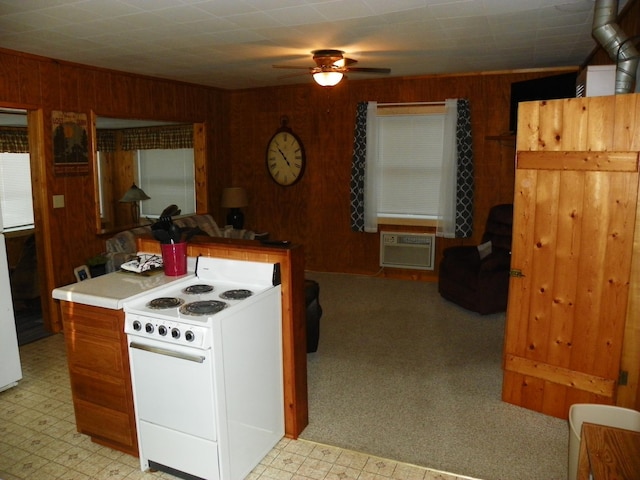 kitchen featuring ceiling fan, wooden walls, a wall unit AC, and white range with electric stovetop