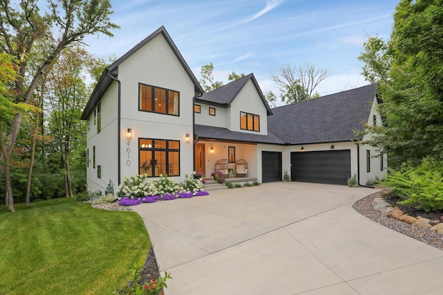 modern farmhouse featuring a garage and a front lawn