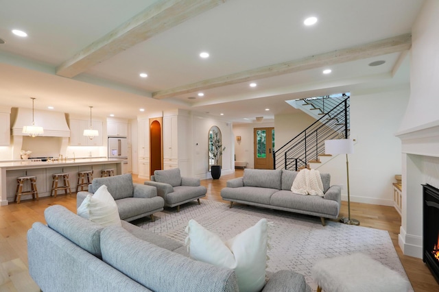 living room featuring light wood-type flooring and beam ceiling