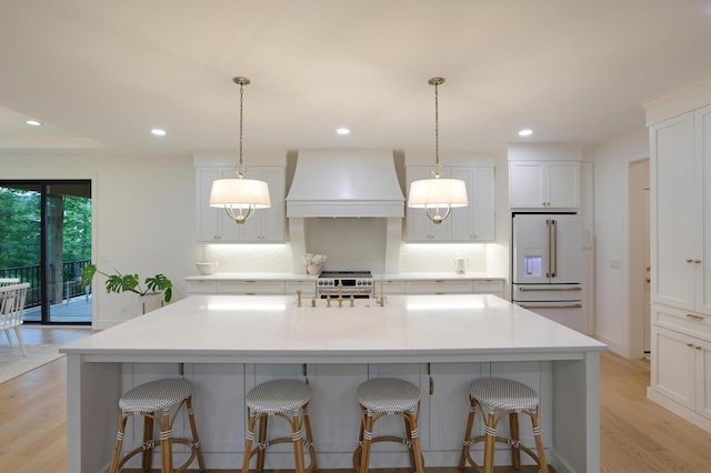 kitchen featuring custom range hood, electric stove, a large island, high end white fridge, and decorative backsplash