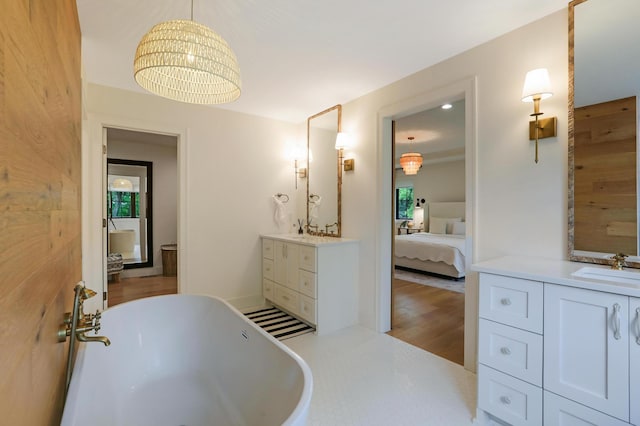 bathroom featuring a tub to relax in, wooden walls, wood-type flooring, and vanity