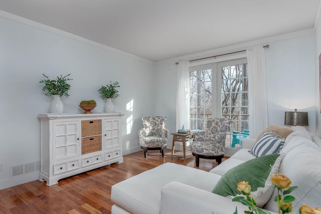 sitting room with wood-type flooring and ornamental molding