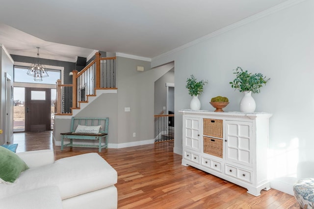 living room featuring an inviting chandelier, ornamental molding, and hardwood / wood-style floors