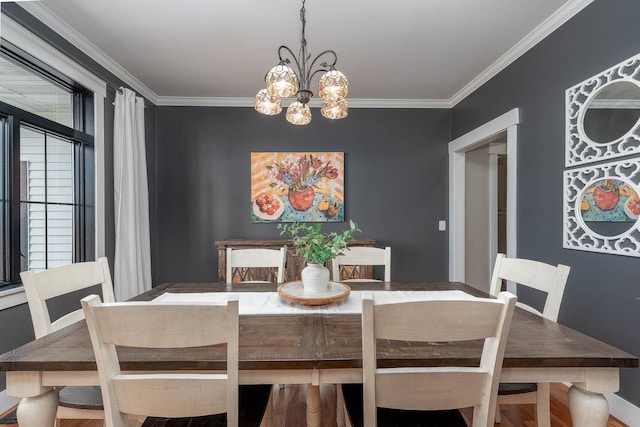 dining space featuring crown molding and a chandelier