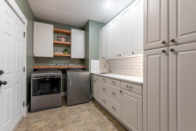 washroom featuring cabinets, separate washer and dryer, and sink