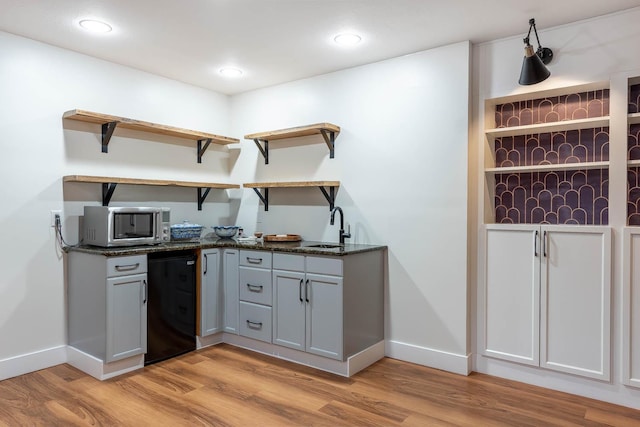 kitchen with fridge, sink, gray cabinetry, and light wood-type flooring