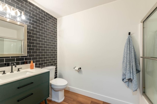 bathroom featuring tile walls, vanity, hardwood / wood-style flooring, and a shower with shower door