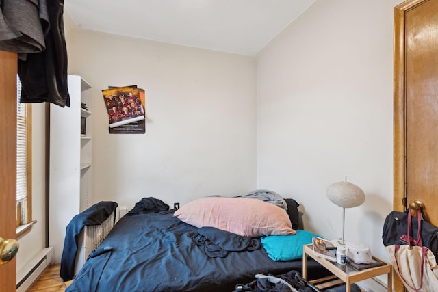 bedroom with baseboard heating and light wood-type flooring