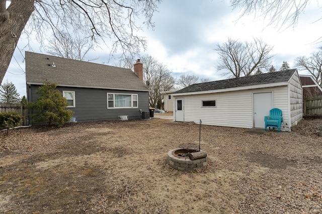 back of house with central AC unit and a fire pit