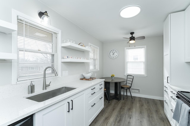 kitchen featuring sink, dark hardwood / wood-style floors, stainless steel electric stove, light stone countertops, and white cabinets