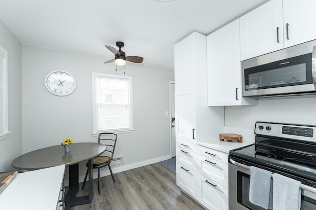 kitchen with ceiling fan, appliances with stainless steel finishes, white cabinets, and light hardwood / wood-style floors