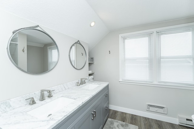 bathroom featuring hardwood / wood-style flooring, vaulted ceiling, vanity, and baseboard heating