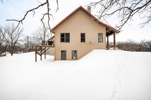 snow covered house with a deck