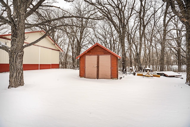 snowy yard featuring a shed