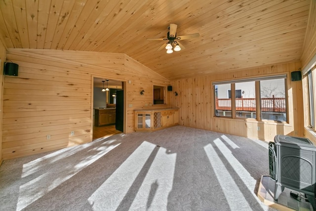 unfurnished living room featuring wooden ceiling, wooden walls, vaulted ceiling, and a wood stove