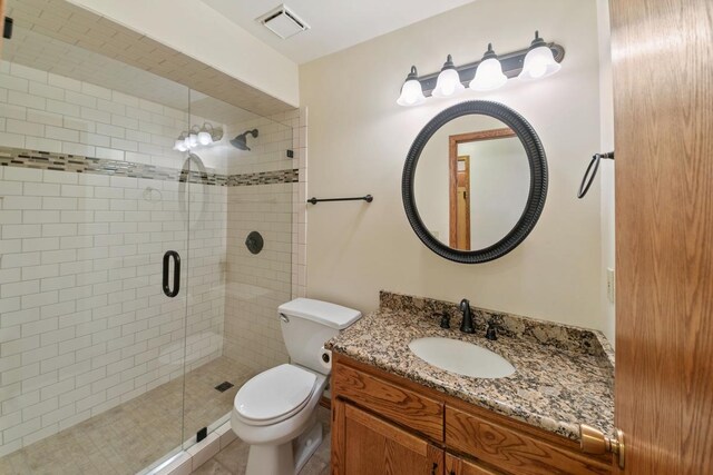 bathroom with walk in shower, vanity, and toilet