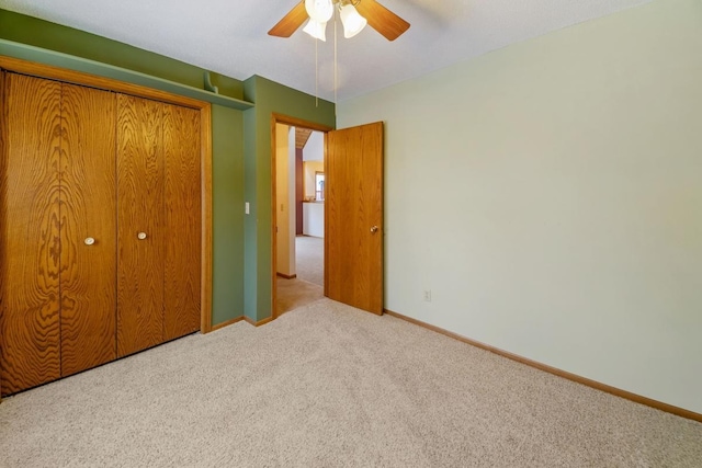 unfurnished bedroom with light carpet, ceiling fan, and a closet