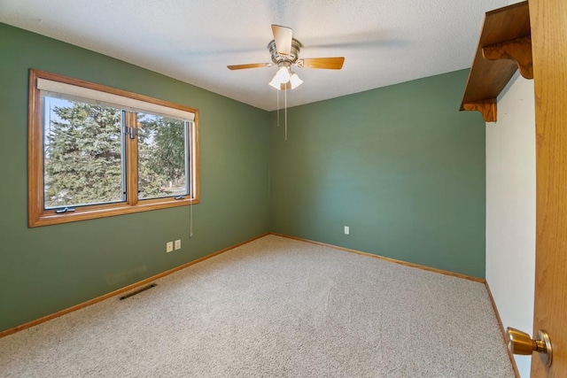 unfurnished room with a textured ceiling, ceiling fan, and carpet flooring