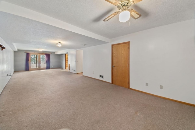 carpeted empty room with ceiling fan and a textured ceiling