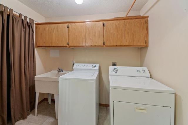 laundry area with separate washer and dryer, cabinets, and a textured ceiling