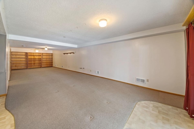 interior space featuring light colored carpet and a textured ceiling