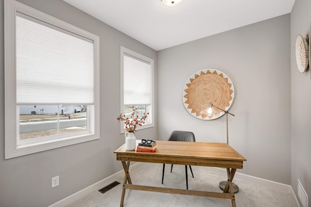 carpeted office space with baseboards and visible vents