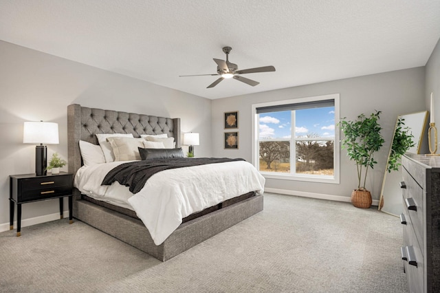 bedroom with baseboards, a textured ceiling, and light colored carpet