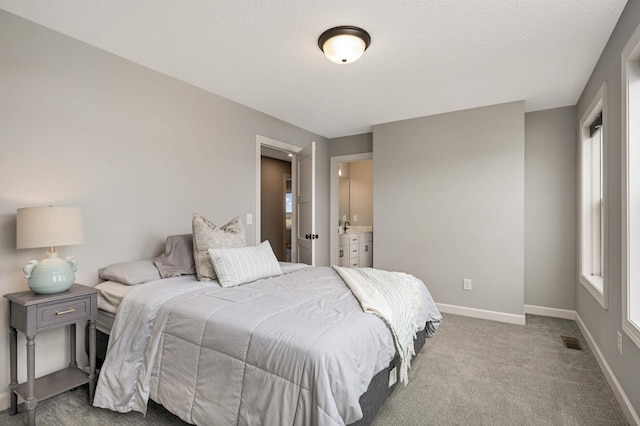 carpeted bedroom with visible vents, a textured ceiling, and baseboards